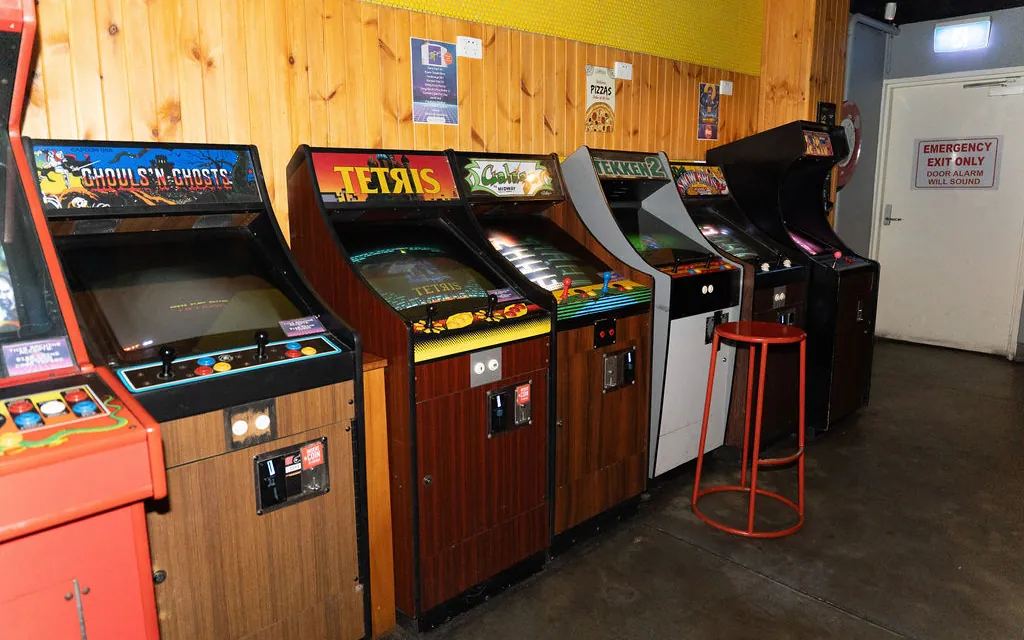 Row of retro arcade cabinets, including Ghouls'n Ghosts, Tetris and Tekken 2, at Bartronica